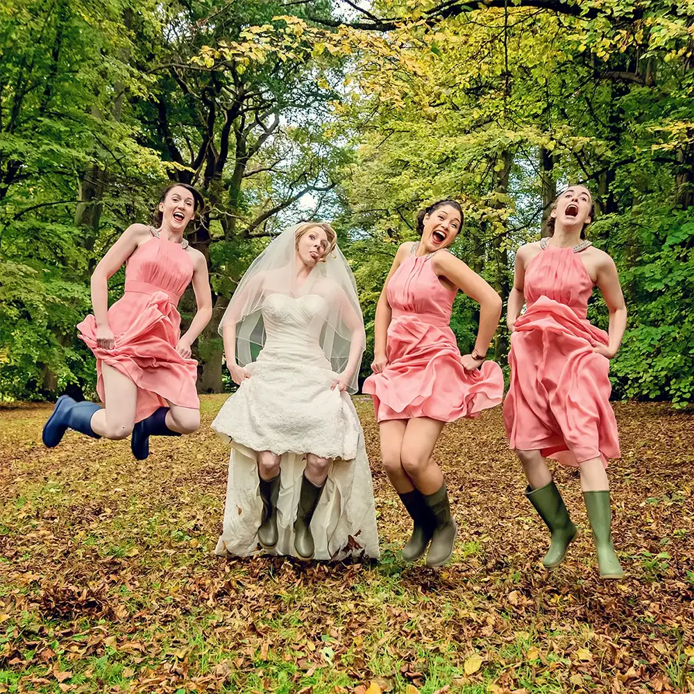 Bridesmaids laughing and jumping together in a Worcester woodland